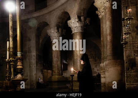 Jerusalem, Israel - May 17, 2014: An Armenian priest traditional night mass in the Church of Holy Sepulchre Stock Photo