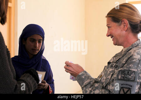 U.S. Army Maj. Carla Brown gives two pairs of socks to an Afghan teenager during a medical civil assistance program at the Nerkh District Center in the Wardak province of Afghanistan Oct. 21, 2009. Brown is a doctor assigned to C Company, 710th  Medical Battalion, attached to 2nd Battalion, 87th Infantry Regiment, 3rd Brigade Combat Team, 10th Mountain Division. US, Afghan troops conduct operations in Wardak province 216013 Stock Photo