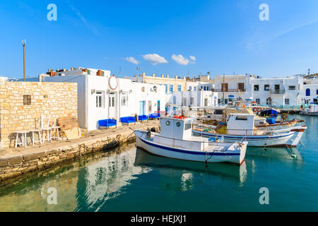 Traditional Greek fishing boats mooring in Naoussa port at sunset time on Paros island, Greece Stock Photo