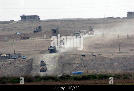 Gun trucks of the Q-West quick reaction force for recovering vehicles descend a valley in Ninewa province, where they will help recover a combat vehicle stuck in a sinkhole, Jan. 18. The recovery QRF - a small detachment of Soldiers from C Company, 2nd Battalion, 198th Combined Arms, 155th Brigade Combat Team, out of Oxford and Indianola, Miss., - assisted members of the 204th Military Police Company, 519th MP Battalion, headquartered in Fort Polk, La. This was their third mission in 30 hours, and during the next 24 hours they would complete three more recoveries with only a few hours of sleep Stock Photo