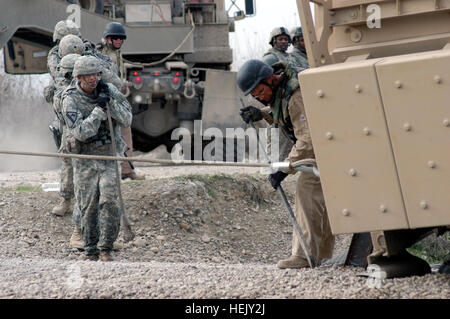 Soldiers with 3rd Platoon, 204th Military Police Company, 519th MP Battalion, headquartered in Fort Polk, La., haul a tow cable toward a Mine-Resistant, Ambush-Protected truck mired in a sinkhole in Ninewa province, Jan. 18. Members of Q-West's quick reaction force for vehicle recovery- manned by C Company, 2nd Battalion, 198th Combined Arms, 155th Brigade Combat Team, out of Oxford and Indianola, Miss. - recovered the vehicle. Mississippi Guardsmen recover vehicles throughout northern Iraq 245933 Stock Photo