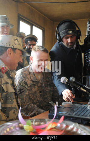 Afghan border police 6th Kandak commander, Col. Niazy and Georgia Army National Guard's 1st Squadron, 108th Cavalry Regiment, Task Force Mountain Warrior commander, Lt. Col. Russell V. Simmons prepare to broadcast a message to the people in the Shinwar District's new radio station. The message was a follow-up to an Anti-Taliban Shiwari Pact jirga at the Kandak headquarters. The radio station is a gift to the people of that region and part of a media information initiative sponsored by the International Security Assistance Force's counterinsurgency program. 'We appreciate the commitment the peo Stock Photo