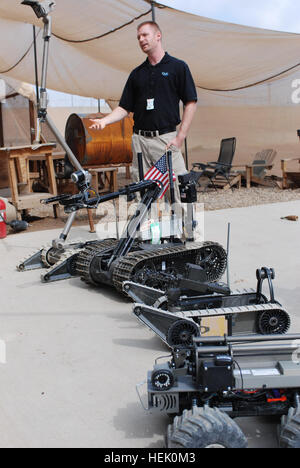 Shawn Wyzlic, a robot technician for the Joint Robotics Repair Detachment and native of Wixom, Mich., discusses the different robots they repair and train Soldiers how to use them for disarming explosives at the Joint Robotics Repair Facility on Camp Victory, Baghdad, Iraq, March 2, 2010. The robots come to the facility when needing repairs or a unit is leaving Iraq so they can be cleaned and given to another unit in need of them. Joint Robotics Repair Detachment keeps robots mission ready 269086 Stock Photo