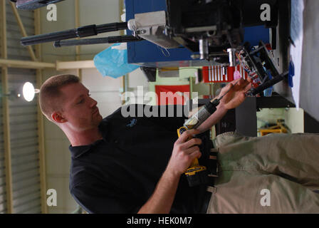 Shawn Wyzlic, a robot technician for the Joint Robotics Repair Detachment and native of Wixom, Mich., repairs a robot, one used to disarm and identify explosives, at the Joint Robotics Repair Facility on Camp Victory, Baghdad, Iraq, March 2, 2010. The robots come to the facility when needing repairs or a unit is leaving Iraq so they can be cleaned and given to another unit in need of them. Joint Robotics Repair Detachment keeps robots mission ready 269090 Stock Photo