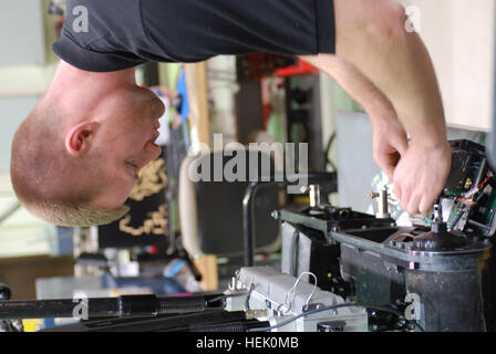 Shawn Wyzlic, a robot technician for the Joint Robotics Repair Detachment and native of Wixom, Mich., repairs a robot, one used to disarm and identify explosives, at the Joint Robotics Repair Facility on Camp Victory, Baghdad, Iraq, March 2, 2010. The robots come to the facility when needing repairs or a unit is leaving Iraq so they can be cleaned and given to another unit in need of them. Joint Robotics Repair Detachment keeps robots mission ready 269096 Stock Photo