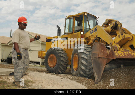 GUANTANAMO BAY, Cuba – Air Force Master Sgt. Curtis Hill (left) directs Tech. Sgt. Carlos Wilson where to grade filler gravel inside Camp America, March 22, 2010. Both service members are from the 186th Civil Engineering Squadron of the Mississippi Air National Guard, deployed to Joint Task Force Guantanamo with the 474th Expeditionary Civil Engineering Squadron. The 474th ECES supports JTF Guantanamo by maintaining the Expeditionary Legal Complex and Camp Justice facilities and infrastructure. JTF Guantanamo conducts safe, humane, legal and transparent care and custody of detainees, including Stock Photo