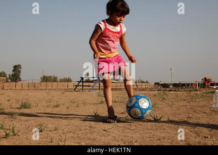 A young girl kicks a soccer ball during the two-day, semi-annual scouting camp-out where the children are taught a wide variety of activities to include fishing, chess, bowling, arts and crafts, and soccer on the Victory Base Complex, Baghdad, Iraq, April 2. The Victory Base Council is a group of volunteers stationed on the VBC that started and support scouting in the areas around Camp Victory. Iraqi Scouting Camp-Out 268392 Stock Photo