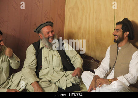 The incoming sub-governor of the Noorgal district, Rama Tullah (right), laughs with  the outgoing sub-governor, Ghaut Pacha (left), during a shura on COP Fortress, May 4, Konar province, Afghanistan. This meeting was to discuss a building project that caused flooding into a local school in a nearby village. Operation Enduring Freedom 276472 Stock Photo