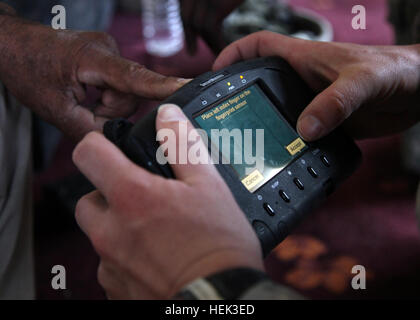 A U.S. Soldier from 3rd Platoon, Aztec Company, 2nd Battalion, 23rd Infantry Regiment, 4th Stryker Brigade, 2nd Infantry Division captures the fingerprints of an Iraqi in Taji, Iraq, May 21. The platoon was verifying the identity of Iraqis selected to receive money for an agricultural project. Identification Verification 284508 Stock Photo