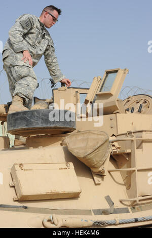 U.S. Army Sgt. Jasen Sumner assigned to Delta Company, 3rd Battalion, 69th Armored Regiment, 1st Brigade, 3rd Infantry Division climbs into the gunners turret of an M1A1 Abrams tank in Joint Security Station Al Rashid, Iraq, July 15. U.S. Soldiers with Delta Company, 3rd Battalion instructed Iraqi tankers on the M1A1 Abrams tank system in support of Operation Iraqi Freedom. M1A1 Tank Drivers Training 303283 Stock Photo