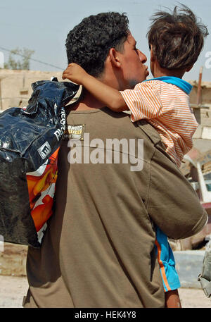 An Iraqi father kisses his son as they leave a humanitarian aid drop conducted, June 26, by Soldiers of Brigade Special Troops Battalion, 1st Advise and Assist Brigade, 3rd Infantry Division. Fifty bags of food, along with bottled water and toys, were distributed to the population living on the outskirts of Baghdad just outside of Contingency Operating Station Falcon. (U.S. Army photo by Sgt. Mary Katzenberger) Desert Cat Soldiers Give Hope 306449 Stock Photo