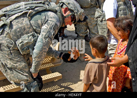 An Iraqi father kisses his son as they leave a humanitarian aid drop conducted, June 26, by Soldiers of Brigade Special Troops Battalion, 1st Advise and Assist Brigade, 3rd Infantry Division. Fifty bags of food, along with bottled water and toys, were distributed to the population living on the outskirts of Baghdad just outside of Contingency Operating Station Falcon. (U.S. Army photo by Sgt. Mary Katzenberger) Flickr - The U.S. Army - Humanitarian aid drop Stock Photo