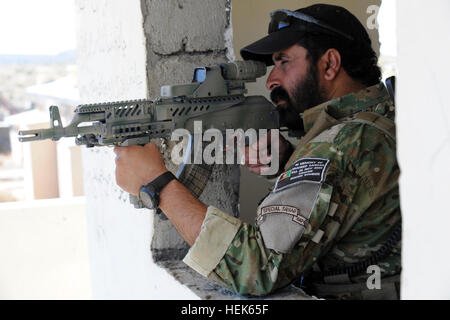 Afghan National Police Commander Azizullah uses the scope on his rifle to scan the area for insurgent activity along the Afghan and Pakistan border, Paktika province, Afghanistan, Sept. 23, 2010. (U.S. Army photo by Sgt. Justin P. Morelli / Released) Afghan border police aiming a weapon Stock Photo