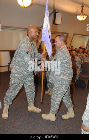 GUANTANAMO BAY, Cuba – Army Lt. Mark Wise passes the JTF HHC guidon to 1st Sgt. Kevin Stapleton during the transfer of authority ceremony at Troopers’ Chapel, Oct. 21.  JTF Guantanamo provides safe, humane, legal and transparent care and custody of detainees, including those convicted by military commission and those ordered released by a court. The JTF conducts intelligence collection, analysis and dissemination for the protection of detainees and personnel working in JTF Guantanamo facilities and in support of the War on Terror. JTF Guantanamo provides support to the Office of Military Commi Stock Photo