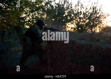 A policeman with 2nd Battalion, 3rd Afghan National Civil Order Police Brigade, provides security during a late afternoon patrol, Nov. 6, with U.S. Special Forces in Zhari District, Kandahar province, Afghanistan. The ANCOP from 2nd Bn. are partnered with members of Special Operations Task Force - South. Night falls on Afghan police, security presence continues 340488 Stock Photo