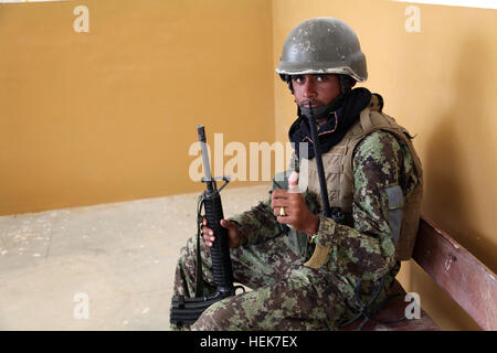 An Afghan National Army soldier takes a covered position in an empty school building after receiving enemy sniper fire in the town of Charkh, Logar province, Afghanistan Nov. 13. Operation Charkh Restoration 341007 Stock Photo