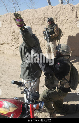 GHAZNI PROVINCE, Afghanistan – A Polish soldier searches a resident during a cordon and search operation in a village near Ghazni City Dec. 22. (Photo by U.S. Army Sgt. Justin Paul Howe, Joint Combat Camera Afghanistan) TF White Eagle, Afghan partners conduct cordon, search operation 353663 Stock Photo
