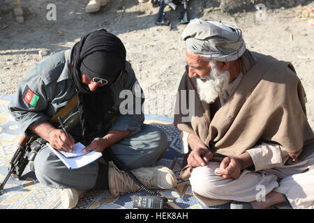 An Afghan National Policeman gathers information about a village from an elder  during operations in Sherzad District, Nangarhar Province, Afghanistan, Dec. 27, 2010. (U.S. Army photo by Spc. Andy Barrera) Operation Black Panther 354322 Stock Photo