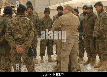PARWAN PROVINCE, Afghanistan – U.S. Army Spc. Thomas Sesker (center, standing), an Ogden, Iowa, resident, shows Afghan National Army soldiers how to conduct a personnel search using U.S. Army Spc. Jason Kincel of Oskaloosa, Iowa, as a demonstrator on Bagram Airfield Dec. 29. Sesker, a vehicle .50-caliber machine gunner, and Kincel, a vehicle driver, are both part of 1st Platoon, Troop B, 1st Squadron of the 113th Cavalry Regiment. Troop B was training with the ANA and the Afghan National Police to prepare for upcoming joint missions. (Photo by U.S. Army Staff Sgt. Ashlee Lolkus, Task Force Red Stock Photo
