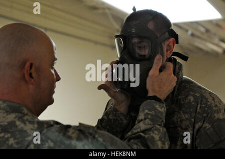 Staff Sgt. Ronald Stephens, a Chemical Biological Radiological Nuclear NCO assigned to Headquarters and Headquarters Company, Brigade Troops Battalion, 1st Stryker Brigade  Combat Team, 25th Infantry Division, Fort Wainwright, Alaska, secures the M41 Gas protective mask on Spc. Thomas Hess, a Geospacial intelligence Specialist, from BTB, 1-25th. Hess, a Washington, District of Columbia Native, is just one of the many Soldiers assigned to the 1-25th who received their protective masks in preperation for the Soldiers deployment to the National Training  Center, in Fort Irwin, Calif. next month.  Stock Photo