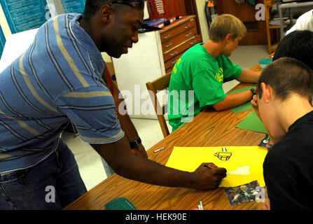 090501-A-0109B-005  GUANTANAMO BAY, Cuba – Coast Guard Petty Officer 3rd Class Isaac Blakely, with Port Security Unit 305, instructs an art student at W.T. Sampson High School, May 1, 2009. Blakely, a Joint Task Force Guantanamo Trooper, is a professional artist and volunteers his time to help enhance the talents of students at U.S. Naval Station Guantanamo Bay. JTF Guantanamo conducts safe, humane, legal and transparent care and custody of detainees, including those convicted by military commission and those ordered released. The JTF conducts intelligence collection, analysis and disseminatio Stock Photo