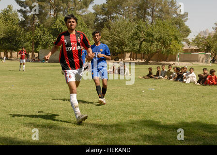 KANDAHAR, Afghanistan - Members from two local soccer teams from the ‘Old Corps’ area of Kandahar City race down the sideline of the field June 8th, as a group of children watch.  The new field was one of many projects headed by 1st Brigade Combat Team, TF ‘Raider’, 4th Infantry Division and their Afghan National Security Forces partners in their joint-reconstruction efforts to improve quality of life, safety and security for residents of Kandahar City. (U.S. Army photo by Sgt. Breanne Pye, Public Affairs Office, 1BCT, 4th Inf. Div.) (110608-A-DE255-151) ANSF, ISAF partner to open new soccer f Stock Photo