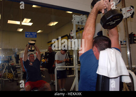 GUANTANAMO BAY, Cuba – Coast Guard Petty Officer 3rd Class Bobby Egger, a boatswain’s mate with the U.S. Coast Guard’s Port Security Unit 307, performs overhead tricep extensions at U.S. Naval Station Guantanamo Bay’s G.J. Denich Gym, Oct. 6, 2008. PSU 307 provides maritime security for the waters around the Naval Station and Joint Task Force Guantanamo.  JTF Guantanamo conducts safe, humane, legal and transparent care and custody of detained enemy combatants, including those convicted by military commission and those ordered released. The JTF conducts intelligence collection, analysis and dis Stock Photo