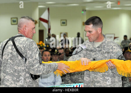 Contingency Operating Base Delta, Iraq – Sgt. Maj. Richard Burnette (left), command sergeant major of 6th 'Saber' Squadron, 9th Cavalry Regiment, 3rd Advise and Assist Brigade, 1st Infantry Division, United States Division – South, and an Anderson, S.C., native, and Lt. Col. Cameron Cantlon (right), commander of 6th Sqdn., 9th Cav. Regt., and a Ettrick, Wis., native, uncase the unit colors during a transfer of authority ceremony, June 15, 2011, at Contingency Operating Base Delta.  After serving four months in Baghdad, Saber Squadron was ordered to move south to assume command of COB Delta and Stock Photo