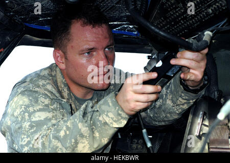 U.S. Army Chief Warrant Officer 2 Brian Caslin, a UH-60 Black Hawk pilot from Rio, Ill., attached to 10th Combat Aviation Brigade, 10th Mountain Division, Task Force Tigershark, connects the heads up display in aircraft during a routine pre-flight inspection on Forward Operating Base Salerno July 21. The HUD is used along with night vision technology for night flights. Black Hawk pilot performs PMCS 110721-A-QO000-048 Stock Photo