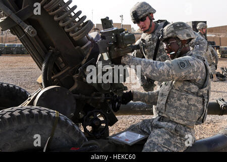 Staff Sgt. Samuel Feldman, section chief, supervises as Sgt. Clarence Robinson, a gunner, raises the elevation of a Howitzer during the cannon crew members' recertification training at Camp Ramadi, Iraq, July 31. All 16 crews in 2nd Battalion, 319th Airborne Field Artillery Regiment of the 82nd Airborne Division's 2nd Advise and Assist Brigade, must recertify every six months to keep their skills sharp and, if necessary, provide accurate fire support. Feldman is a native of Mount Clemens, Mich., while Robinson is originally from Atlanta, Ga. Both Paratroopers are assigned to A Battery, 2-319th Stock Photo