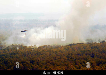 A Texas National Guard UH-60 Black Hawk dumps water over a wild fire. Texas National Guard crews launched out of the Austin Army Aviation Facility to fight wild fires threatening homes and property near Bastrop, Texas, Sept. 6, 2011. Texas National Guard helicopters battle Bastrop blaze 110906-A-FG822-010 Stock Photo