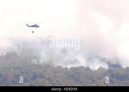 A Texas National Guard UH-60 Black Hawk dumps water over a wild fire. Texas National Guard crews launched out of the Austin Army Aviation Facility to fight wild fires threatening homes and property near Bastrop, Texas, Sept. 6, 2011. Texas National Guard helicopters battle Bastrop blaze 110906-A-FG822-012 Stock Photo