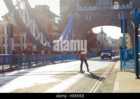 Tower Bridge, London, UK. 22nd Dec, 2016. A skateboarder crosses the bridge ahead of the first cars. Tower Bridge, the 122-year old iconic landmark on the River Thames, reopens to traffic following a 3 month closure for essential maintenance work to its Grade I listed structure. Credit: Imageplotter News and Sports/Alamy Live News Stock Photo