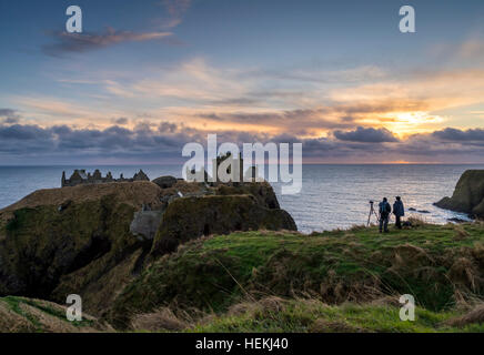 Photographers capturing the sunrise this morning at Dunnottar Castle, near Aberdeen in Scotland. Stock Photo