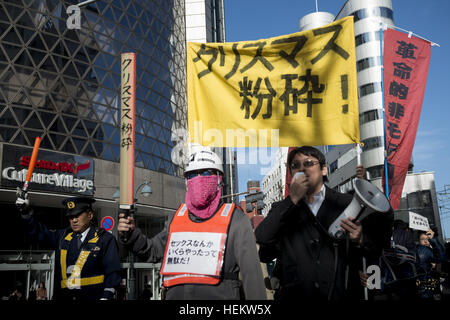 Tokyo, Tokyo, Japan. 24th Dec, 2016. Protesters hold banner reading 'Smash Christmas Day'' as they shout slogans during a march at Tokyo's Shibuya shopping and amusement district. The members of the group known as Kakuhidou, gathered and marched on Saturday against what they called the ''Christmas capitalists' BLO, D-soaked plot to victimize consumersâ © Alessandro Di Ciommo/ZUMA Wire/Alamy Live News Stock Photo