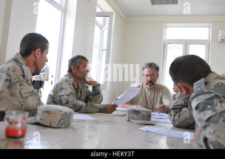 Mike Studer, an employee with DynCorp, trains Afghan Border Police patrolmen on logistics forms at the Border Police Headquarters near the Shir Khan border crossing point Oct. 3, 2011. A platoon of U.S. Army soldiers with 40th Engineer Battalion, 170th Infantry Brigade Combat Team, provided security for a group of civilian professionals who train with Afghan Border Policemen. Afghan border crossing at Sher Khan in Kunduz Province Stock Photo