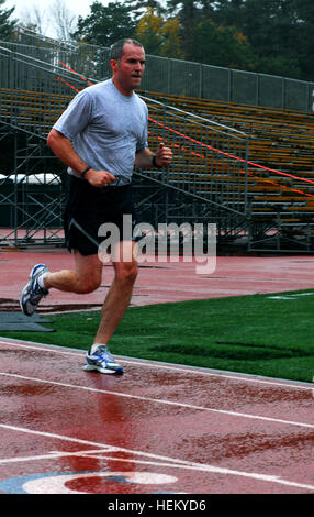 U.S. Air Force Staff Sgt. Michael Johnson, a combat arms instructor with the 157th Security Forces Squadron of the New Hampshire National Guard, runs the 5000 meter portion of the German Armed Forces Proficiency Badge test at the University of New Hampshire in Durham,N.H., Oct. 13, 2011. Johnson and 14 other guardsmen participated in the rigorous physical testing, which included, track and field events, shooting, swimming, and a 7 1/2 mile march. In the test Johnson was one of only nine to earn gold, the highest award. (U.S. Army photo by Spc. Margaret Taylor / Released) U.S. Air Force Staff S Stock Photo