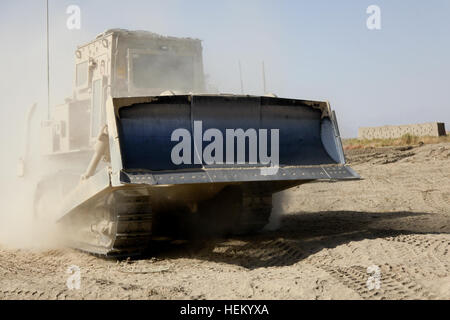 A bucket loader in Mullayan, Kandahar province, Afghanistan, on November 1, 2011, pours sand into HESCO barriers to construct walls for a new military strong point near the village. Stock Photo