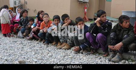 Afghan children sit in line, waiting to receive school supplies at the Egyptian Field Hospital, Nov. 10.  Members of the Regional Command-East Female Engagement Team Program Directorate handed out supplies here during a weekly women’s clinic. The team’s education initiative, Operation School Supplies, aims to provide educational tools to empower women and children, impacting Afghanistan’s future leaders. (U.S. Army photo by Capt. Ebony N. Calhoun, 7th Mobile Public Affairs Detachment/Released) Operation School Supplies 487588 Stock Photo