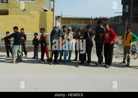 Local children gather on the streets of Jabella, Iraq, to see the soldiers of 1st Brigade Combat Team, 1st Cavalry Division during a joint mission with Iraqi Security Forces, Nov. 12, 2011. The 1st Cavalry Division brigade worked to continue developing an enduring partnership with Iraqis while simultaneously closing down three of the last U.S. bases in Iraq. Turning off the lights in Iraq, A look back 519035 Stock Photo