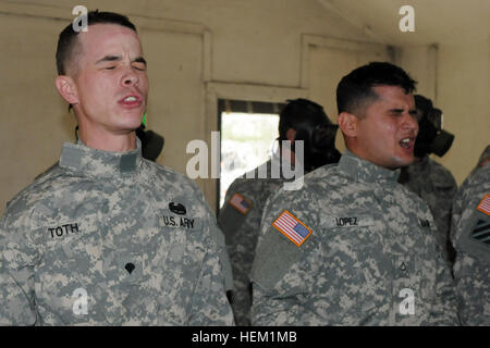 Spc. Andrew E. Toth and Pfc. Guiovanny Lopez, cavalry scouts with B Troop, 6th Squadron, 8th Cavalry Regiment, 4th Infantry Brigade Combat Team, 3rd Infantry Division, attempt to sing the “Dog-Faced Soldier Song” after removing their field protective masks in a CS gas chamber, Jan. 9, during quarterly Chemical, Biological, Radiological and Nuclear training on Fort Stewart, Ga. 'Vanguard' soldiers unmask with confidence during CBRN training 120109-A-RV385-140 Stock Photo