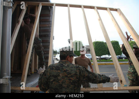 U.S. Navy Seabees from Mobile Construction Battalion 23, along with Peruvian Marine engineers, load prefabricated floors onto a truck aboard High Speed Vessel Swift at Callao Naval Base. They are collaborating on a three-week project to refurbish two schools in Zona De Acapulco and Ancon as part of Southern Partnership Station 2012. Stock Photo