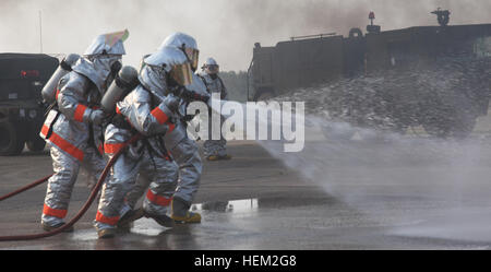 Royal Thai Air Force fire fighters spray water over gasoline during a fire rescue and medical safety demonstration held in support of Exercise Cobra Gold 2012 at Wing One Royal Thai Airforce Base, Nakhon Ratchasima, Kingdom of Thailand, Feb. 9, 2012. The demonstration consisted of a joint effort in fire rescue and medical safety procedures by participating nations in CG 12. The exercise improves the capability to plan and conduct combined joint operations, building relationships between partnering nations and improving interoperability across the Asia-Pacific region. Exercise Cobra Gold 2012 1 Stock Photo