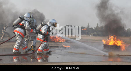 Royal Thai Air Force Fire Fighters spray water over gasoline during a fire rescue and medical safety demonstration held in support of Exercise Cobra Gold 2012 at Wing One Royal Thai Air Force Base, Nakhon Ratchasima, Kingdom of Thailand, Feb. 9, 2012. The demonstration consisted of a joint effort in fire rescue and medical safety procedures by participating nations in CG 12. The exercise improves the capability to plan and conduct combined joint operations, building relationships between partnering nations and improving interoperability across the Asia-Pacific Region. Exercise Cobra Gold 2012  Stock Photo