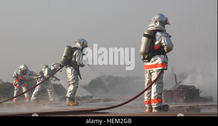 Royal Thai air force fire fighters spray water over gasoline during a fire rescue and medical safety demonstration held in support of Exercise Cobra Gold 2012 at Wing One Royal Thai air force base, Nakhon Ratchasima, Kingdom of Thailand, Feb. 9, 2012. The demonstration consisted of joint efforts in fire rescue and medical safety procedures by participating nations in CG 12. The exercise improves the capability to plan and conduct combined joint operations, building relationships between partnering nations and improving interoperability across the Asia-Pacific Region. Exercise Cobra Gold 2012 1 Stock Photo