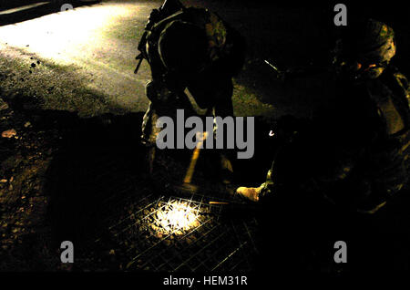 Combat engineers from the 3rd Brigade Special Troops Battalion, 3rd Brigade Combat Team, 82nd Airborne Division, clear a crater and fill it with cement on Main Supply Route Tampa in Tikrit, Iraq, to maintain route security and prevent roadside bomb activity, ensuring safe movement of supplies. Stock Photo