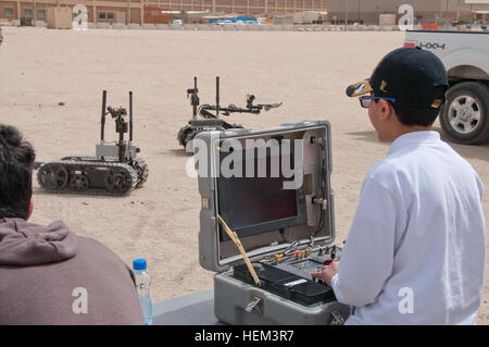 Kuwaiti students from the American School of Kuwait operate explosive ordnance disposal robots and interact with U.S. soldiers during a base tour at Camp Arifjan on March 22, demonstrating team-building exercises and bilateral engagement between U.S. and Kuwaiti military personnel. Stock Photo