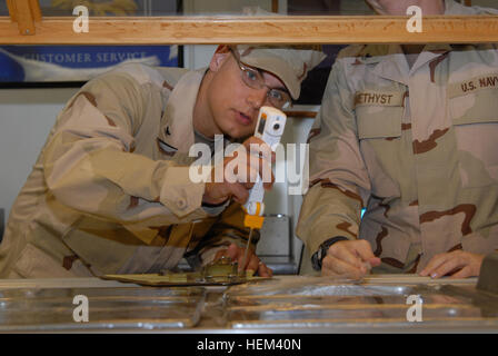 GUANTANAMO BAY, Cuba – Navy Petty Officer 3rd Class Nicholas Ullrich, a preventive medicine technician with Joint Task Force Guantanamo, takes the temperature of food in the salad bar, Oct. 15, 2009. The JTF galleys, and all galleys at U.S. Naval Station Guantanamo Bay, are regularly inspected for sanitation and cleanliness. JTF Guantanamo conducts safe, humane, legal and transparent care and custody of detainees, including those convicted by military commission and those ordered released by a court. The JTF conducts intelligence collection, analysis and dissemination for the protection of det Stock Photo