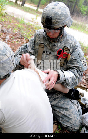 Spc. Jason Martin, a medic, wraps a casualty's shoulder during a casualty evacuation exercise, April 19. During the event, a group of paratroopers assigned to the 2nd Brigade Combat Team, 82nd Airborne Division's 1st Squadron, 73rd Cavalry Regiment, were injured when a roadside bomb detonated along their patrol. The medics triaged and treated the casualties, transported them to the aid station, and evacuated them on a UH-60 Black Hawk. Designed to challenge the medics, the exercise was the culmination of their field training and taught them how to react in a worst-case scenario. Martin is assi Stock Photo