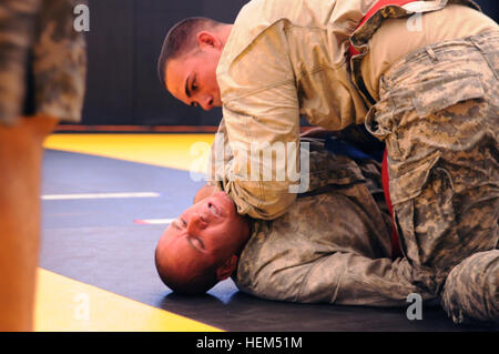 Staff Sgt. Brian Bower (top), a combat engineer with Arizona Army National Guard 819th Sapper Company, maintains a hold on his opponent Staff Sgt. Craig Pace, a human resources NCO with Utah Army National Guard Headquarters, 204th Maneuver Enhancement Brigade, during their combatives bout in the 2012 Region VII Best Warrior Competition at Camp San Luis Obispo, Calif., April 25. The combatives event challenged competitors to submit their opponent within six minutes using an authorized hold, or win by majority of points gained throughout the match using various moves. (Army National Guard photo/ Stock Photo